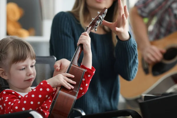 Mutter nimmt Tochter Musikinstrument aus der Hand, um zu zeigen, wie man spielt — Stockfoto