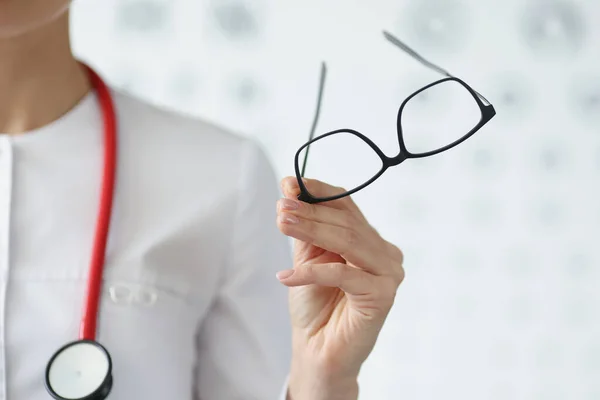 Profesjonalny lekarz okulista trzymać okulary w czarnej ramce — Zdjęcie stockowe