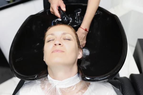 Mulher se sentir relaxado e confortável ao obter lavagem capilar com shampoo e massagem no salão de beleza — Fotografia de Stock