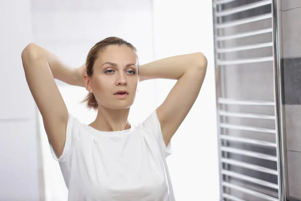 Giovane donna che si guarda allo specchio in bagno, fingendo di essere bella, routine mattutina — Foto Stock