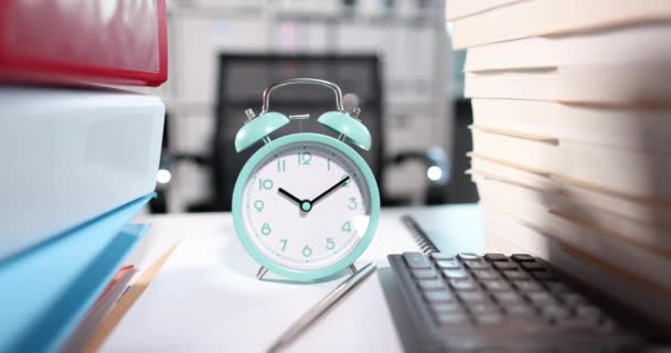 Reloj despertador para diez de la mañana junto con muchos documentos en el escritorio — Vídeos de Stock