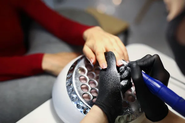 El maestro de uñas utiliza equipos especiales para trabajar con los clientes manicura — Foto de Stock