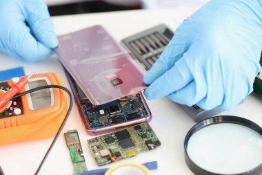 Erkek, cep telefonu kablosu bağlantılarına arka panel taktı