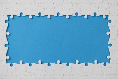 Ortasında eksik parçalar olan beyaz yapboz çerçevesi, ortasında boş boşluk