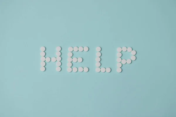 Ajuda letras feitas com pílula redonda branca, prescrição de medicamentos para o tratamento — Fotografia de Stock