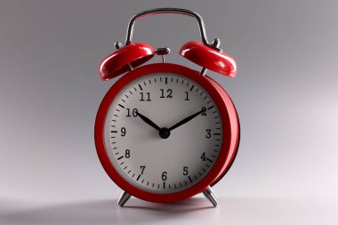 Gri arkaplanda duran kırmızı klasik alarm saati