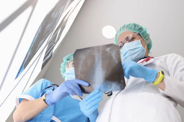 Los trabajadores médicos examinan la radiografía de los pulmones del paciente, colegas discuten resultado de exploración —  Fotos de Stock