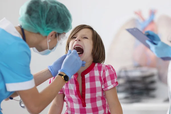 Petit enfant bouche ouverte pour l'examen, mal à la gorge, rendez-vous chez le pédiatre vérifier avec l'outil — Photo