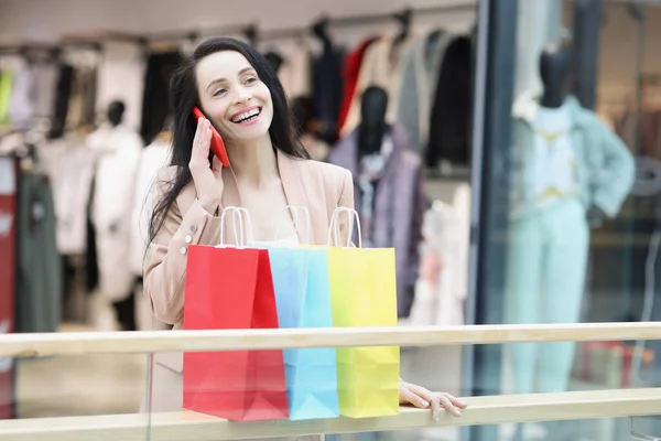Fiatal nő shopaholic mosolyog, és mondd meg a barátodnak ügyeletes értékesítési — Stock Fotó