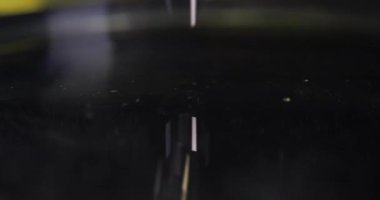 Yağlı sarı sıvı, siyah sıvı ağır çekimde 4K filme damlıyor.