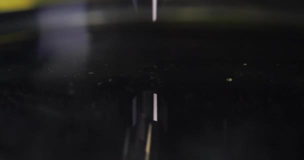 黒い液体の遅い動きに油っぽい黄色の液体滴4kムービー — ストック動画
