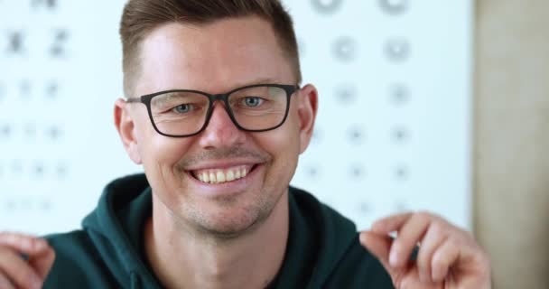 Porträtt av ung leende man tar av glasögon slow motion 4k film — Stockvideo