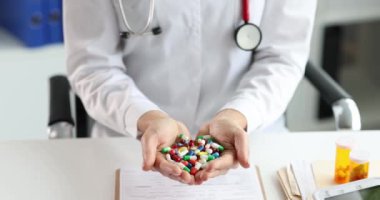 Doktor elinde çok renkli haplar tutuyor. Ağır çekimde 4K film.