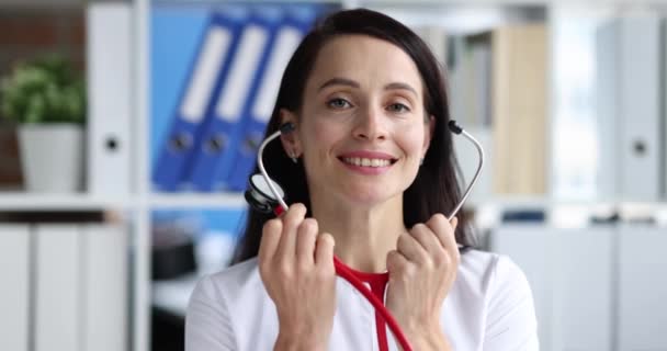 Портрет улыбающейся женщины-врача со стетоскопом замедленной съемки 4К фильма — стоковое видео