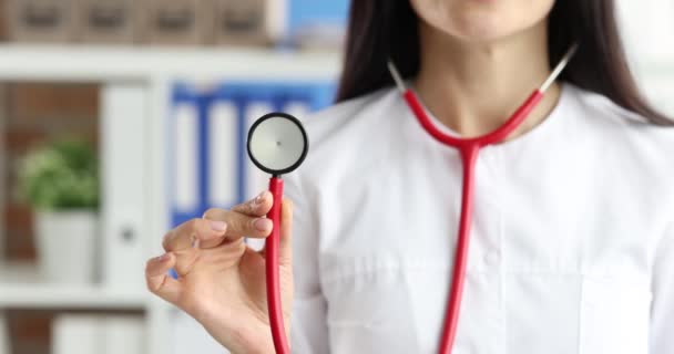 Médico feminino segurando estetoscópio vermelho câmera lenta filme 4k — Vídeo de Stock
