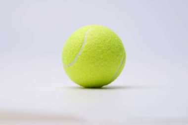 Beyaz arka planda parlak kireç tenis topu yakın plan