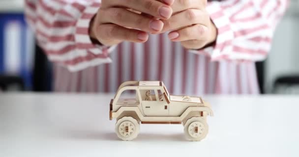 Female hands hugging and protecting toy wooden car 4k movie slow motion — Stock Video