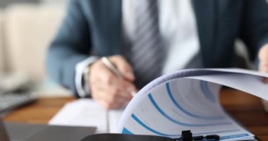 Takım elbiseli bir işadamı ofiste evrak dolduruyor. 4K film kapanıyor.