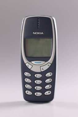 Minsk, Belarus, 08 Aralık 2021: Gri arkaplan üzerinde cep telefonu Nokia 3310 mavi