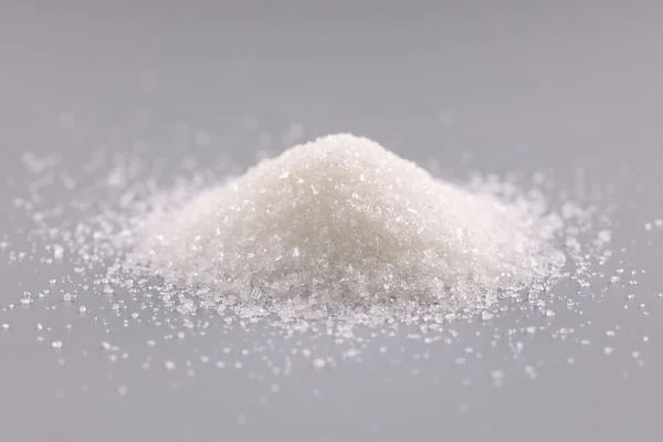 Deslize de açúcar branco no fundo cinza — Fotografia de Stock