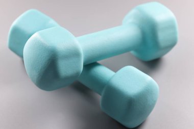 Gri arkaplanda mavi iki kilogram dambıl