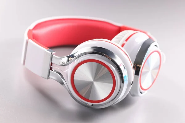 Λευκά κόκκινα ασύρματα ακουστικά σε γκρι φόντο — Φωτογραφία Αρχείου