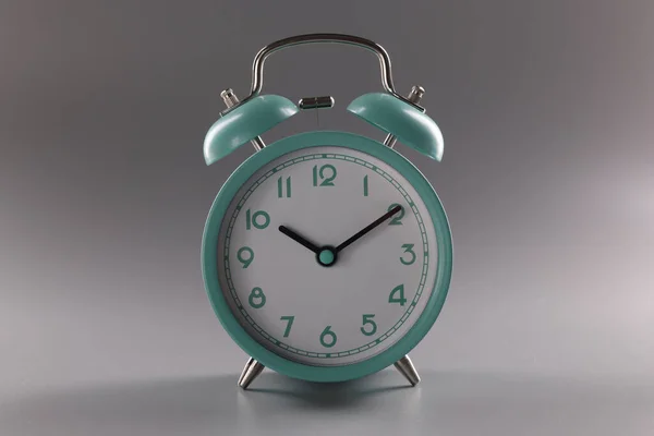 Бирюзовый будильник в 10 часов на сером фоне — стоковое фото