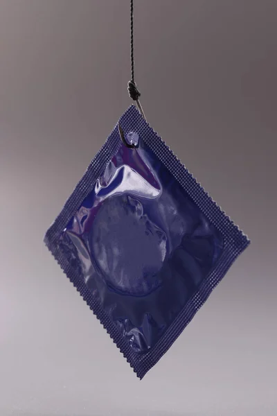 Gri arka planda mavi prezervatif ambalajı. Güvenli seks kuralları — Stok fotoğraf