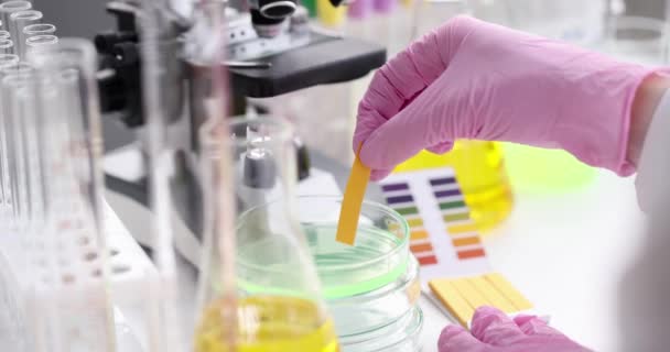 Forskare i handskar bedriver ph-ray forskning i mikrobiologi lab — Stockvideo