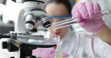 Laboratuvarda mikroskop kullanarak çalışma jeli şeffaf sıvı kullanıyor.