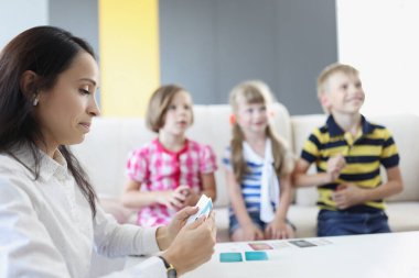 Bir grup çocuk anaokulunda bayan öğretmenle vakit geçiriyor.