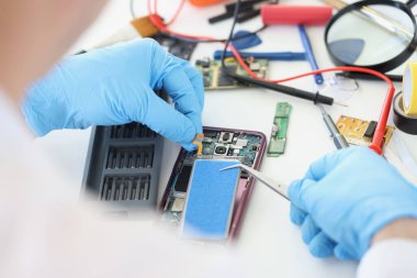 Bozuk cep telefonu modelini tamir eden, içine yeni pil takan, eski cep telefonunu hayata döndüren biri.