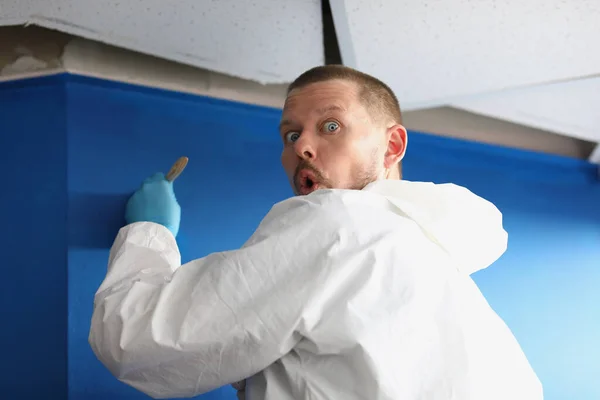 Travailleur masculin pris par surprise mur de peinture en couleur bleue — Photo