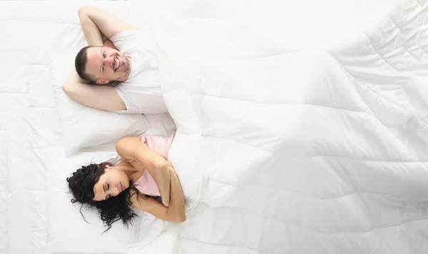 Vrouw en man gelukkig liggend bed, witte beddengoed — Stockfoto