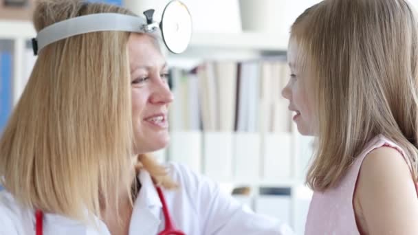 ЛОР-врач осматривает маленькое ухо девочки с помощью отоскопа — стоковое видео