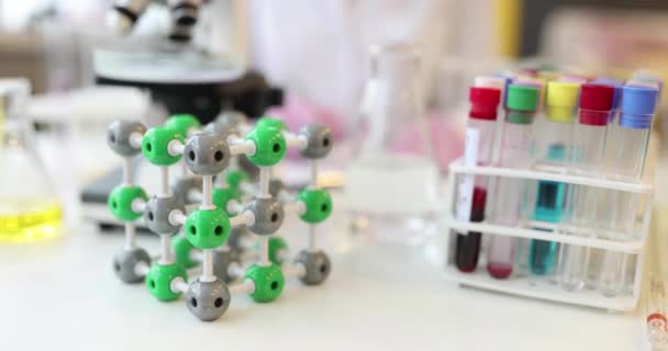 Wissenschaftler arbeitet im Hintergrund des Molekül-Reagenzglases — Stockvideo