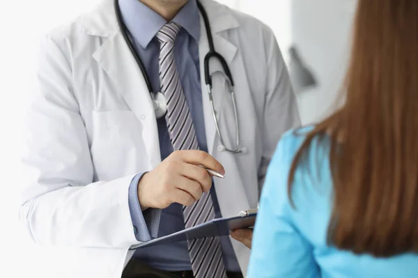 Hombre médico en uniforme y estetoscopio consultar paciente mujer — Foto de Stock