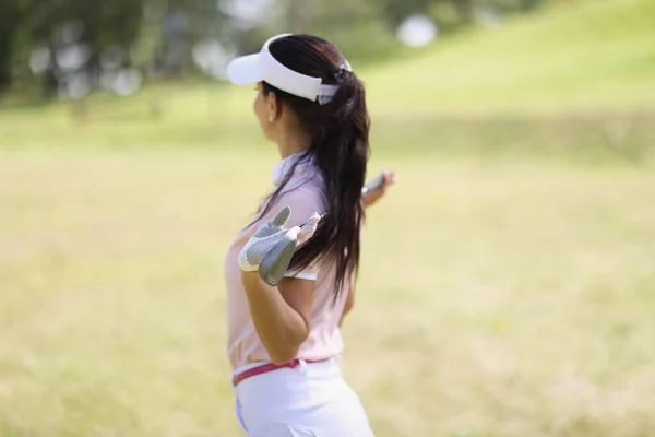 Professionele vrouw golfspeler poseren met golfclub op het veld — Stockfoto