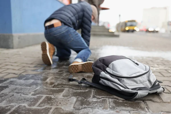 Homem se levanta do chão depois de cair no asfalto escorregadio no inverno — Fotografia de Stock