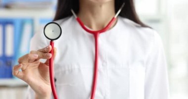 Beyaz önlüklü doktor steteskoplu ağır çekimde 4K film tutuyor.