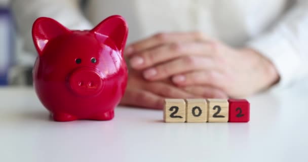 红色猪猪仔银行和数字2022的立方体放在桌上 — 图库视频影像