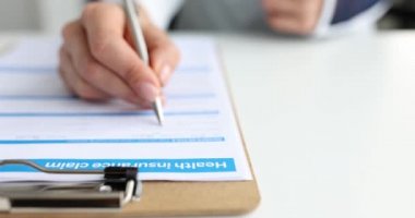 Eli yaralanmış bir müşteri sağlık sigortası talep formunu dolduruyor.