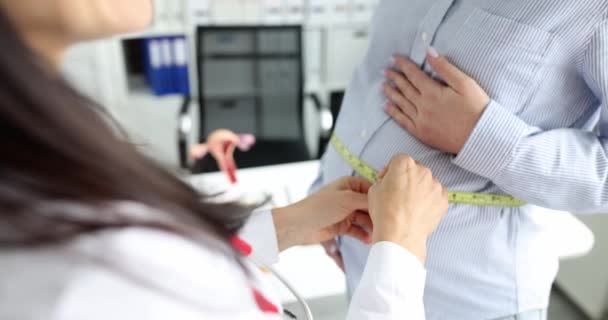 婦人科医は妊娠中の女性の腹をセンチメートルで測定する — ストック動画