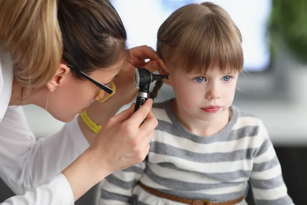 Liten flicka sitta lugn medan husläkare undersöka öron med särskild utrustning — Stockfoto