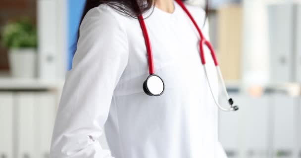 Женщина-врач в медицинской форме с красным стетоскопом крупным планом — стоковое видео