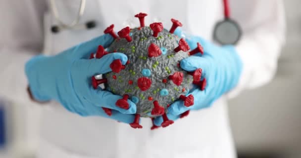 Plastik eldivenli doktor Coronavirus 'un yapay modelini tutuyor. Yakın çekim 4K film yavaş çekim. — Stok video