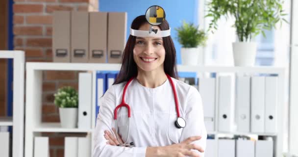 Портрет улыбающейся женщины-врача с фронтальным отражателем на голове 4К фильм замедленной съемки — стоковое видео