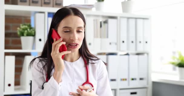 Žena lékař mluví na mobilním telefonu na klinice 4k film zpomalení — Stock video