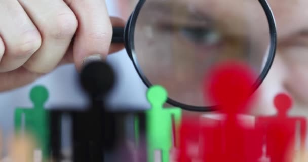 Zakenman op zoek naar veelkleurige speelgoedfiguren van mannen door vergrootglas closeup 4k film slow motion — Stockvideo