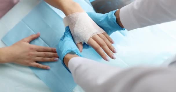 Dokter verband patiënt gewond arm in kliniek closeup 4k film — Stockvideo